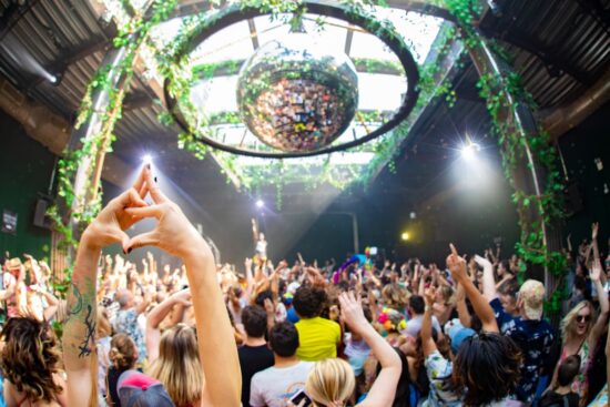 DJ animando la fiesta Daybreaker en una azotea de Nueva York al amanecer.