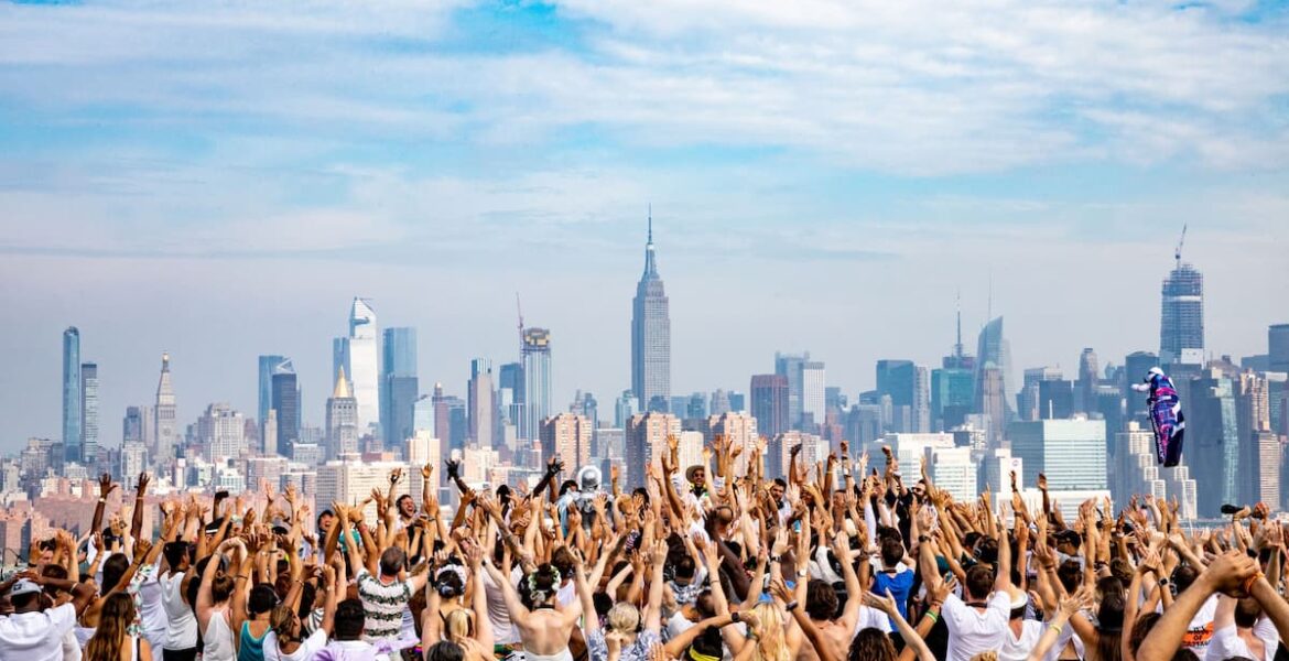 Fiesta Daybreaker al amanecer en Nueva York con gente bailando y celebrando bajo el sol.