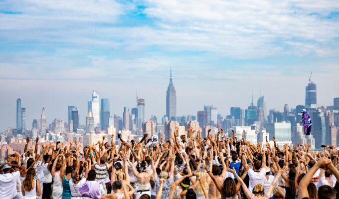 Fiesta Daybreaker al amanecer en Nueva York con gente bailando y celebrando bajo el sol.