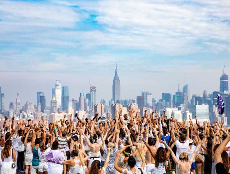 Fiesta Daybreaker al amanecer en Nueva York con gente bailando y celebrando bajo el sol.
