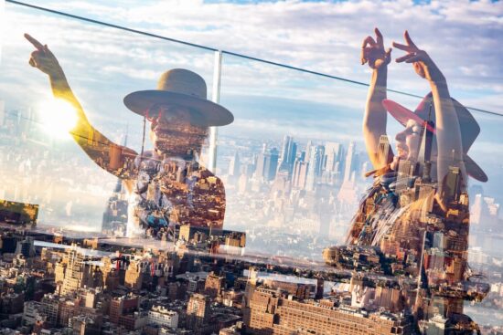 Gente bailando al amanecer con vista al skyline de Nueva York en un evento Daybreaker.