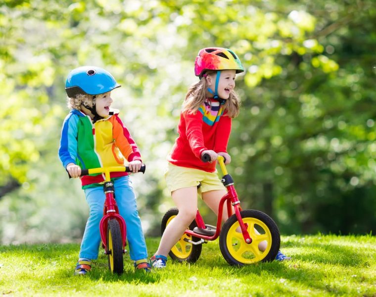 Niños en bicicletas de equilibrio aprendiendo con método Montessori.