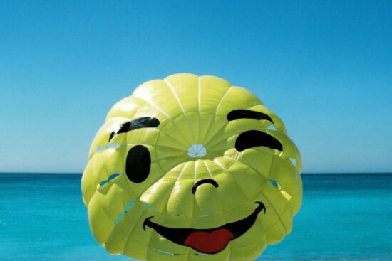 Imagen de paracaídas con carita feliz, guiñando un ojo