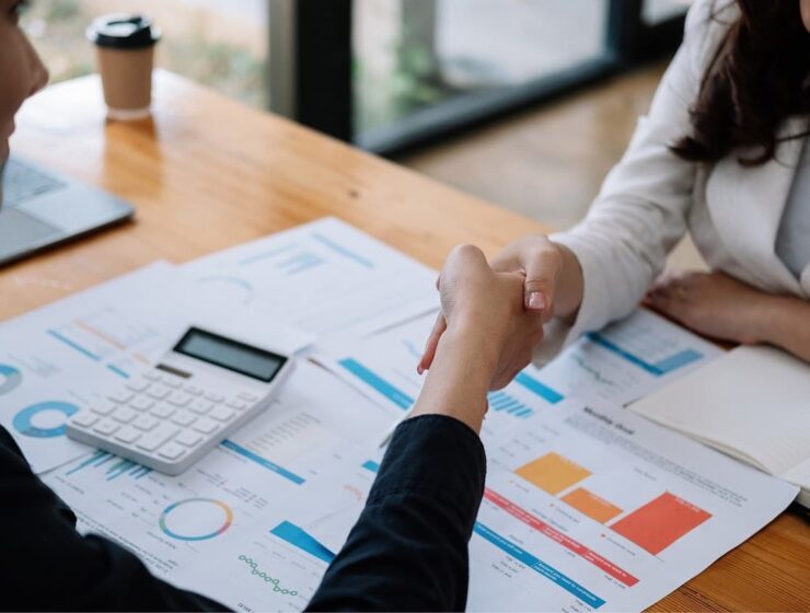 Persona estrechando la mano en una reunión laboral para negociar aumento de sueldo.