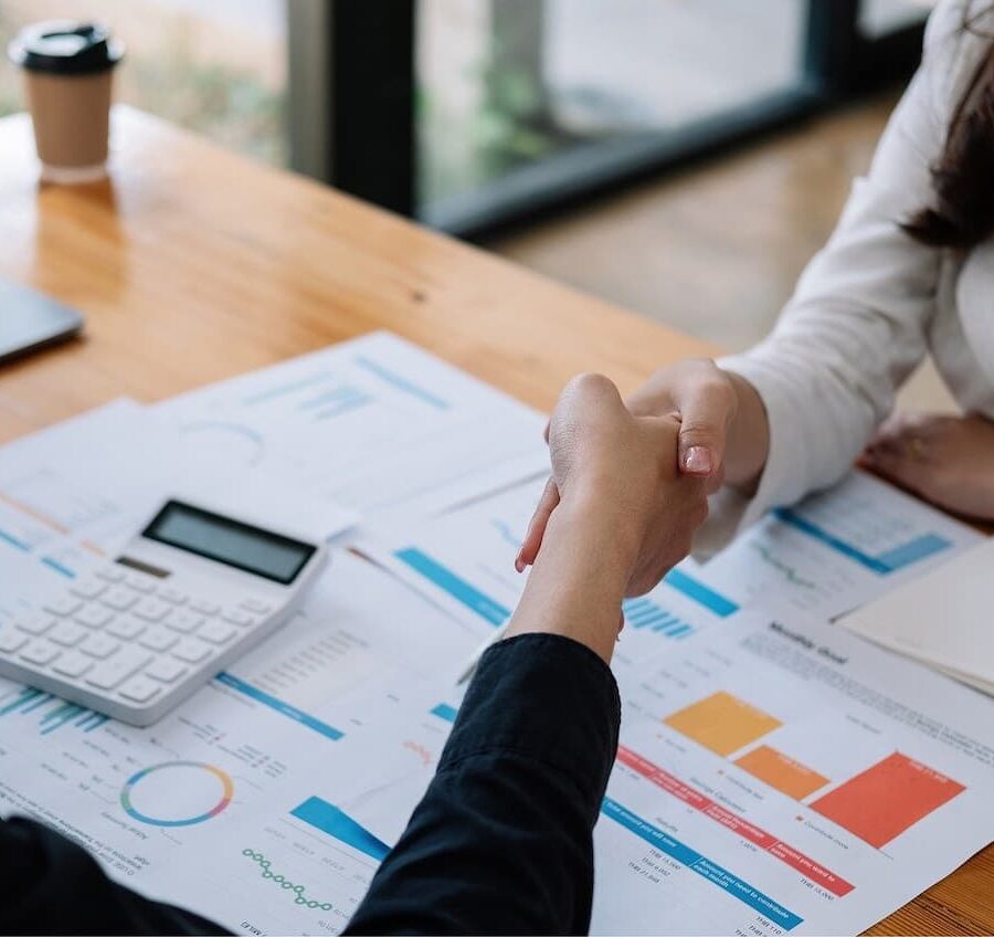 Persona estrechando la mano en una reunión laboral para negociar aumento de sueldo.