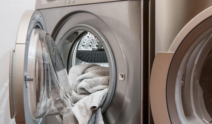 Toalla colgando en una lavadora abierta