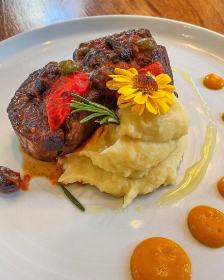 Plato gourmet en Amayta Recoleta: carne con puré, vegetales y flor comestible.