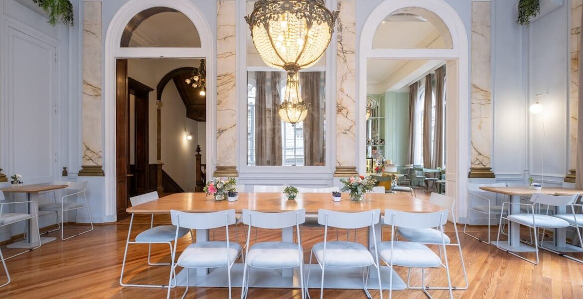 Salón de Amayta con lámpara de araña, espejos y mesa larga en Recoleta.