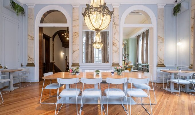 Salón de Amayta con lámpara de araña, espejos y mesa larga en Recoleta.