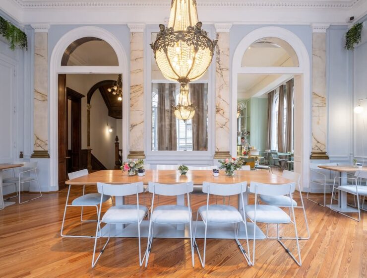 Salón de Amayta con lámpara de araña, espejos y mesa larga en Recoleta.