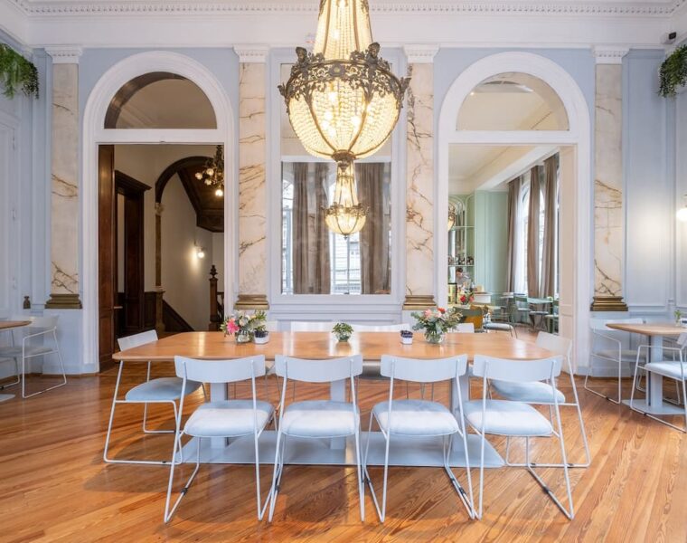 Salón de Amayta con lámpara de araña, espejos y mesa larga en Recoleta.