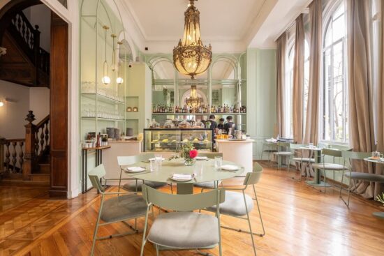 Salón de Amayta en Recoleta con barra, lámpara de araña y mesas elegantes.