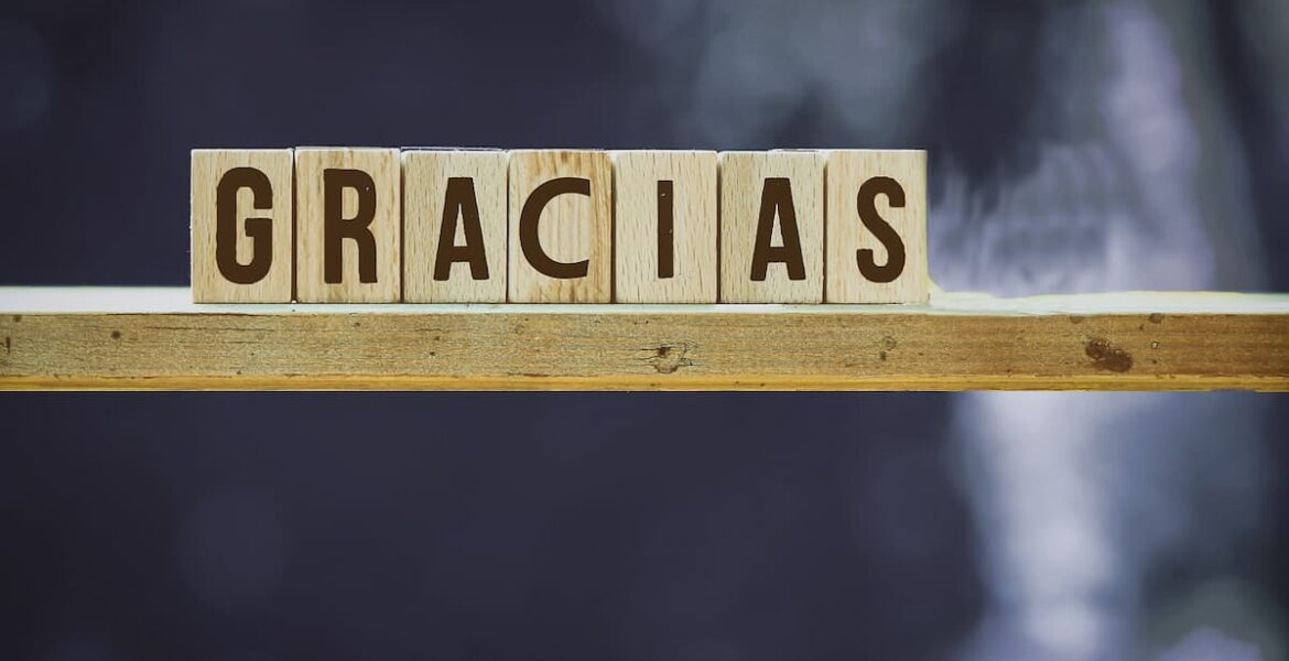 Bloques de madera formando la palabra gracias sobre un fondo neutro