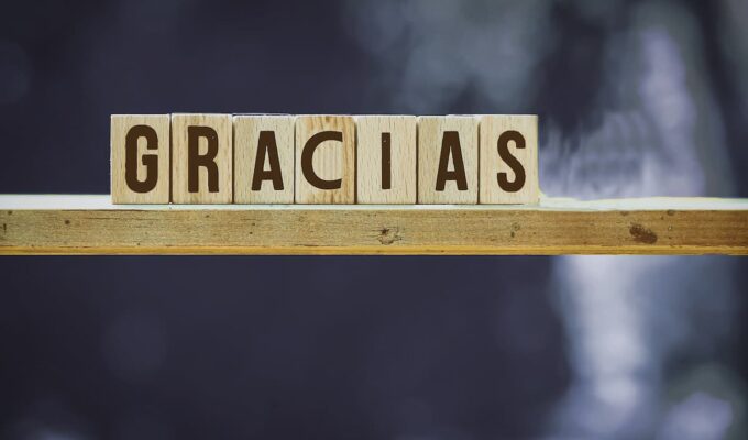 Bloques de madera formando la palabra gracias sobre un fondo neutro