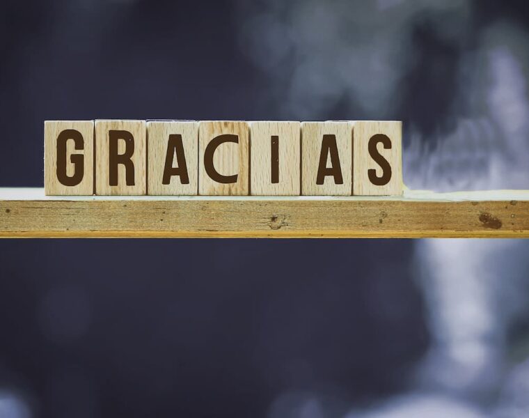 Bloques de madera formando la palabra gracias sobre un fondo neutro