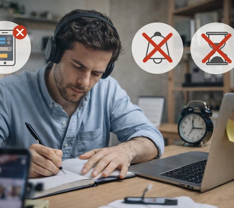 Hombre concentrado trabajando y evitando distracciones digitales en su escritorio