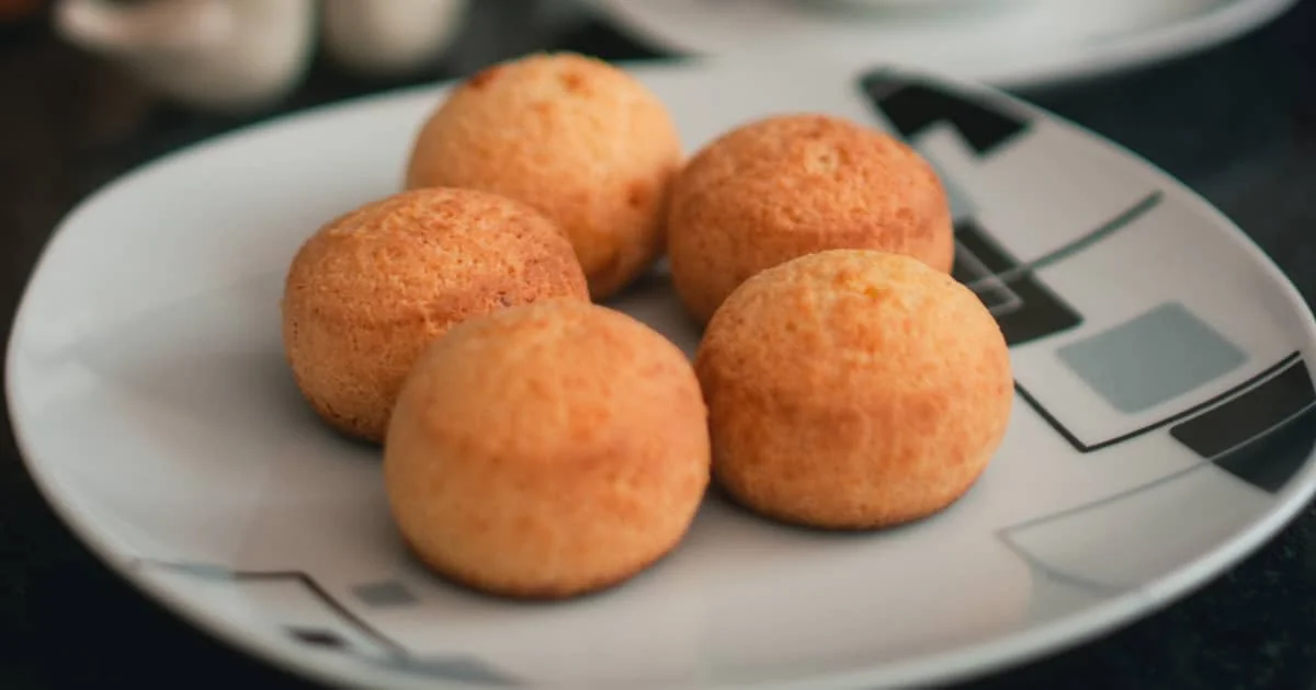 Cuenco blanco con pan de queso esponjoso recién horneado