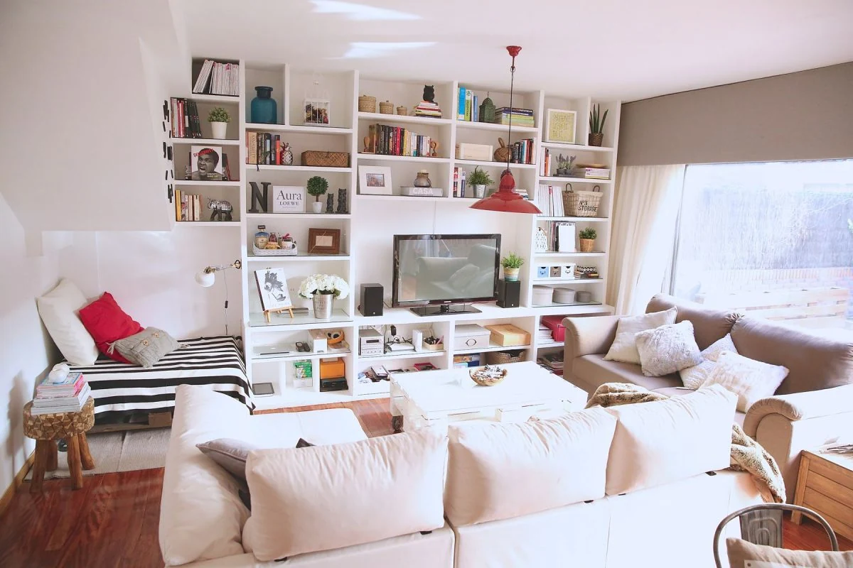 Sala comedor moderna con estantería blanca y sofá en tonos crema