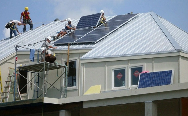 Personas instalando paneles solares en un tejado Tipos de paneles solares modernos