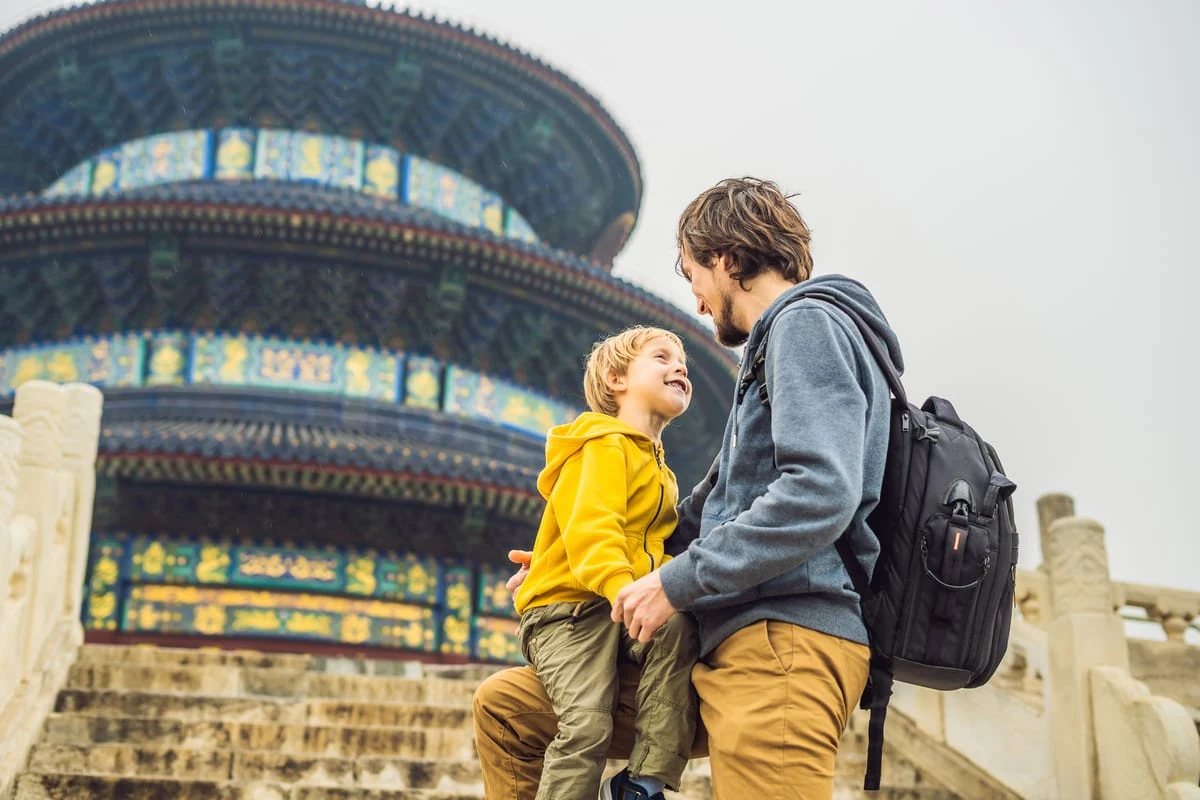 Padre e hijo compartiendo un momento feliz mientras viajan y visitan un templo, una idea de regalo de viaje inolvidable para el Día del Padre.