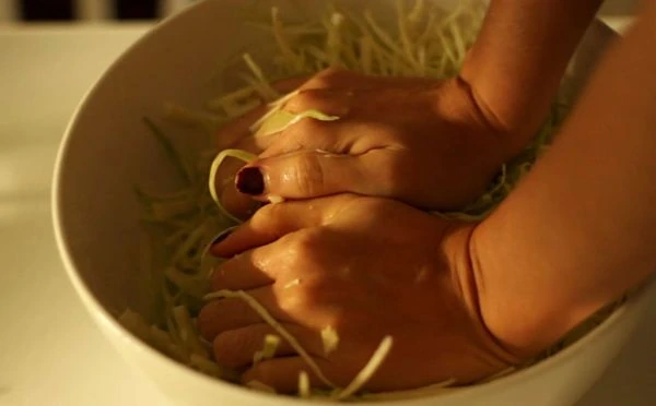 mujer haciendo chucrut en un bowl