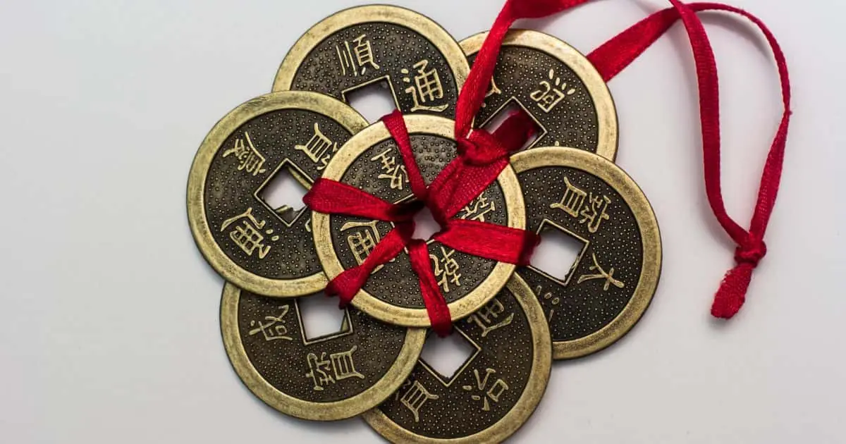 Monedas chinas antiguas atadas con una cinta roja, símbolo tradicional de prosperidad y buena fortuna.