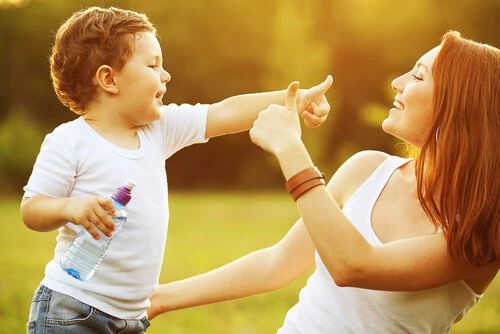 Madre e hijo jugando juntos con alegría y refuerzo positivo.