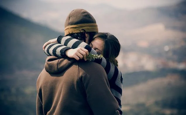 Pareja abrazada en una montaña