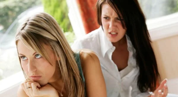 Dos mujeres con gestos de tensión y frialdad, ilustrando que recuperar la confianza y la normalidad en una amistad requiere tiempo y paciencia.