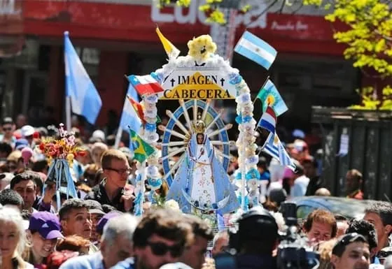 Multitud de peregrinos llevando la imagen de la Virgen de Luján durante la peregrinación anual a pie hacia la Basílica en Argentina.