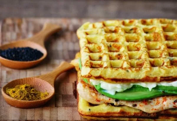 Los waffles salados incluir rellenos muy diversos. Waffls con pasta de atún y aguacate, condimentado con cúrcuma y pasas.
