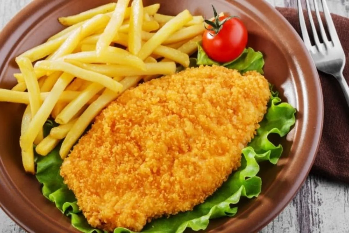 Milanesa de pollo empanizada con papas a la francesa