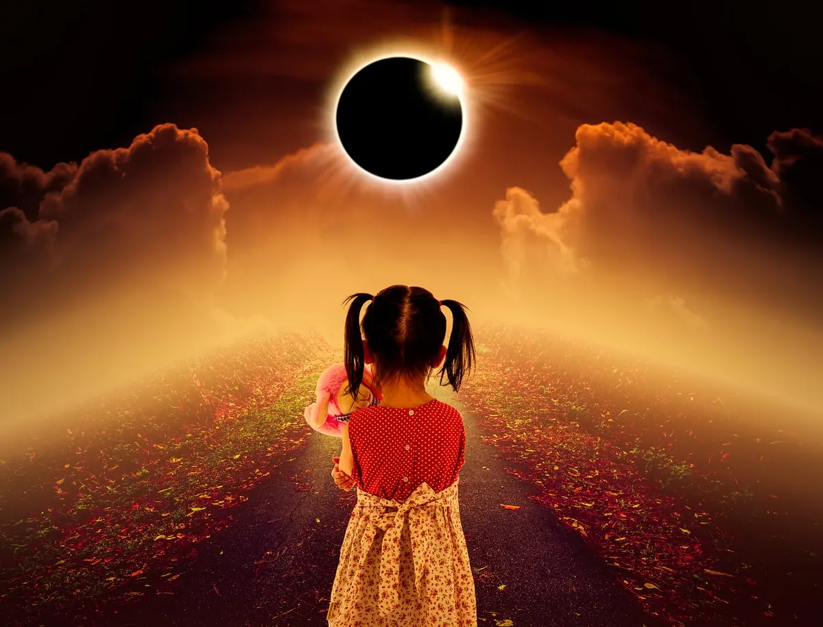 Niña observando un eclipse solar total. Niña mirando un eclipse solar en un camino rodeado de hojas y nubes.