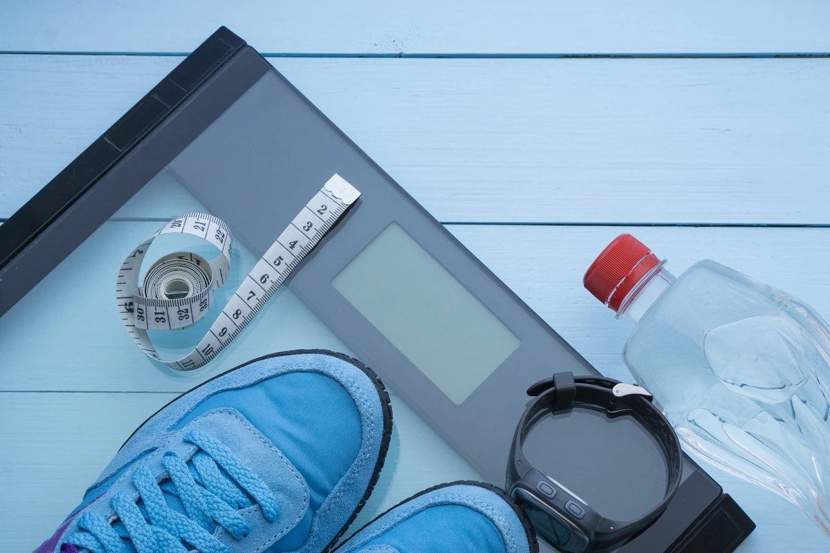 báscula digital fitness con zapatillas cinta métrica y botella de agua