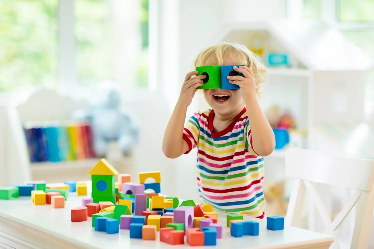 Juego Montessori para descubrir el mundo con alegría Niño jugando con bloques Montessori y descubriendo el mundo con alegría.