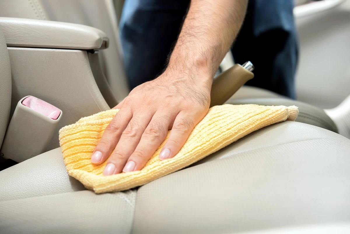 Mano aplicando pasta dental con paño de microfibra sobre rayón