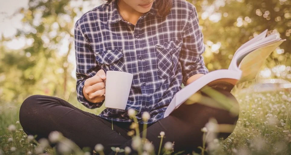 Joven disfrutan la lectura al aire libre