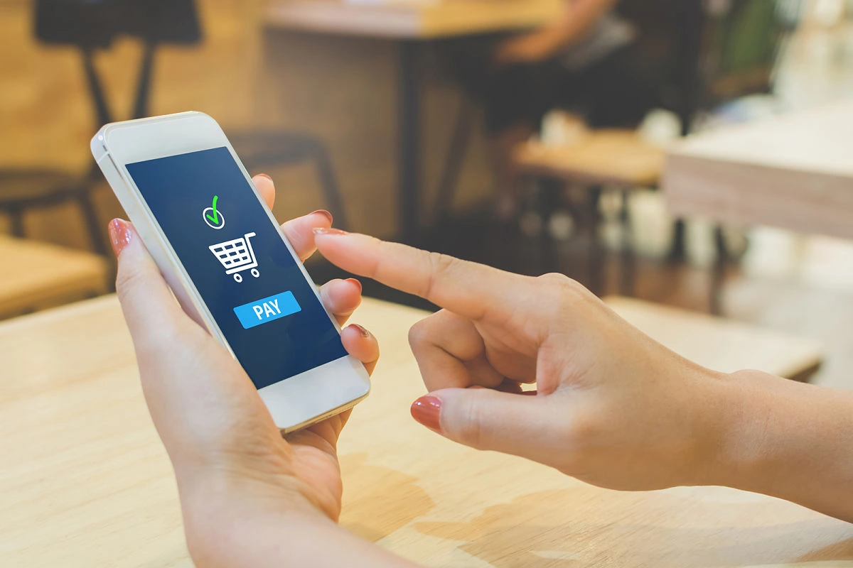 Punto de realizar un pago online desde su celular, completando una compra en una tienda de e-commerce de forma fácil y rápida.