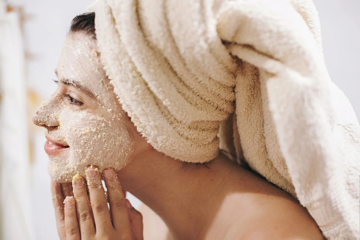 Mujer joven exfoliando su rostro con espuma limpiadora