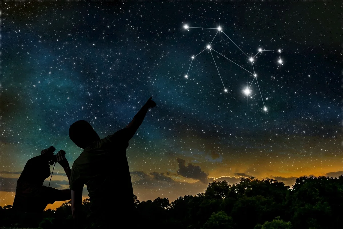 Dos personas observando las constelaciones, representando cómo las alineaciones planetarias son clave para el descubrimiento de exoplanetas por la NASA.