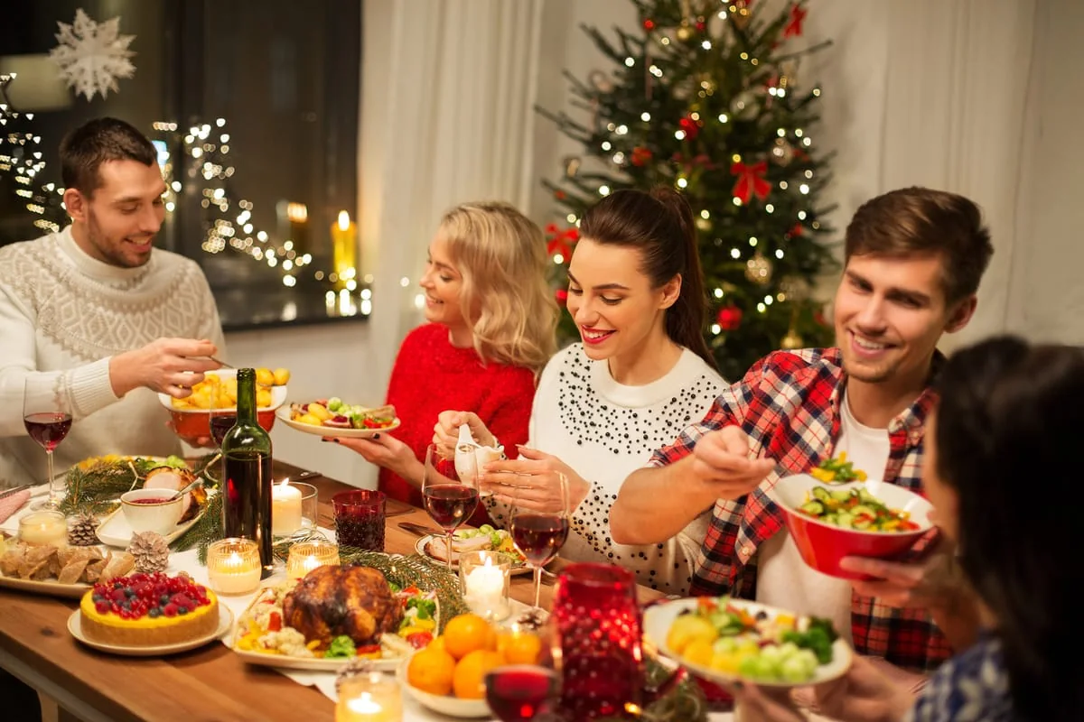 Familia celebrando la cena de Navidad con comida tradicional y decoración festiva.