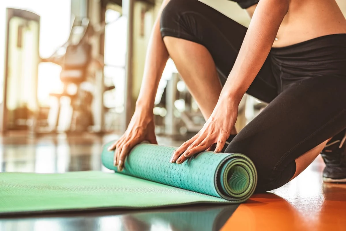 Terapeuta física preparando una esterilla de ejercicios para una sesión de rehabilitación, una de las profesiones con mejores oportunidades y alto crecimiento.
