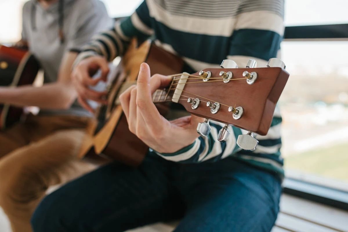 Músico tocando una guitarra acústica, representando la pasión por las guitarras de colección y su valor como ediciones especiales.