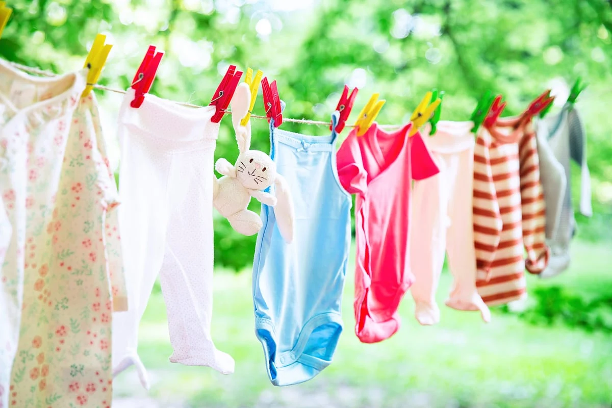 ropa de bebé colgada para que se seque al sol en un jardín o campo