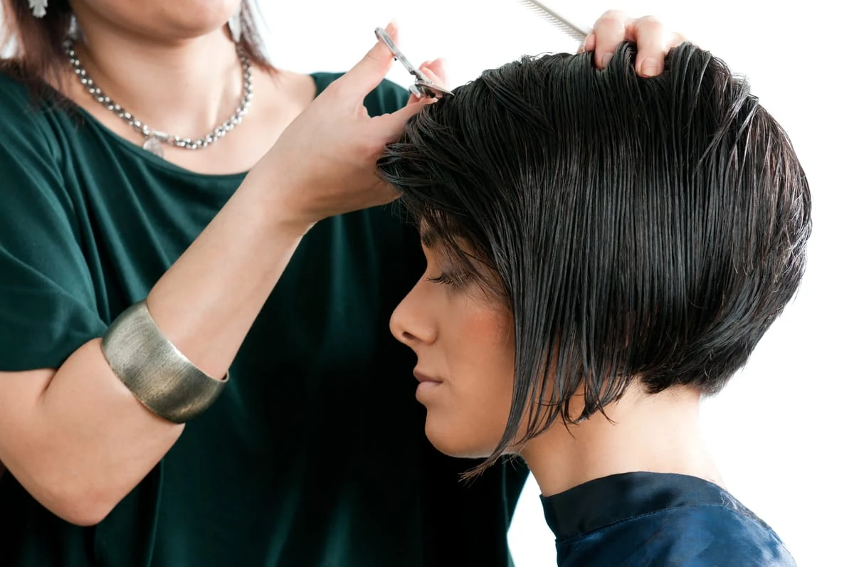 Mujer cortándose el cabello corto para estar a la moda