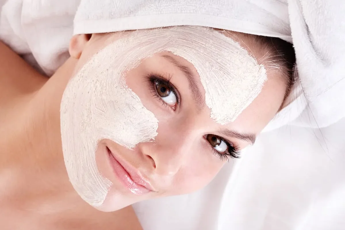 Mujer con mascarilla facial hidratante durante rutina de cuidado de la piel