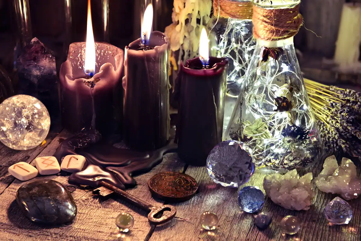El Poder de un Ritual Mágico. Altar mágico con velas negras, cristales, runas vikingas y hierbas, preparado para un ritual de protección o manifestación en la brujería moderna.