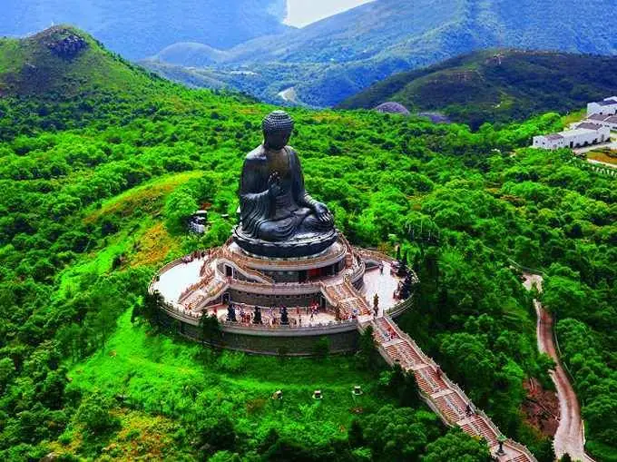 Gran Buda de Tian Tan en las montañas de Hong Kong Vista aérea del Gran Buda de Tian Tan, una monumental estatua de Buda ubicada sobre una colina rodeada de vegetación en la isla de Lantau, Hong Kong.