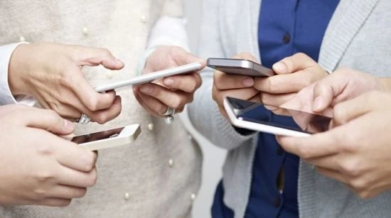 personas usando teléfonos móviles al mismo tiempo mostrando el uso excesivo del celular en la vida cotidiana