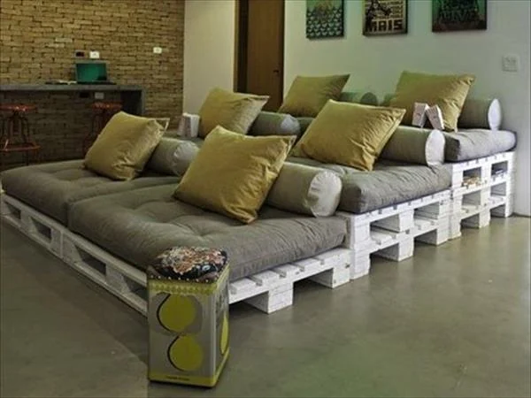 Gran sofá cama de palets blancos con cojines tipo futón